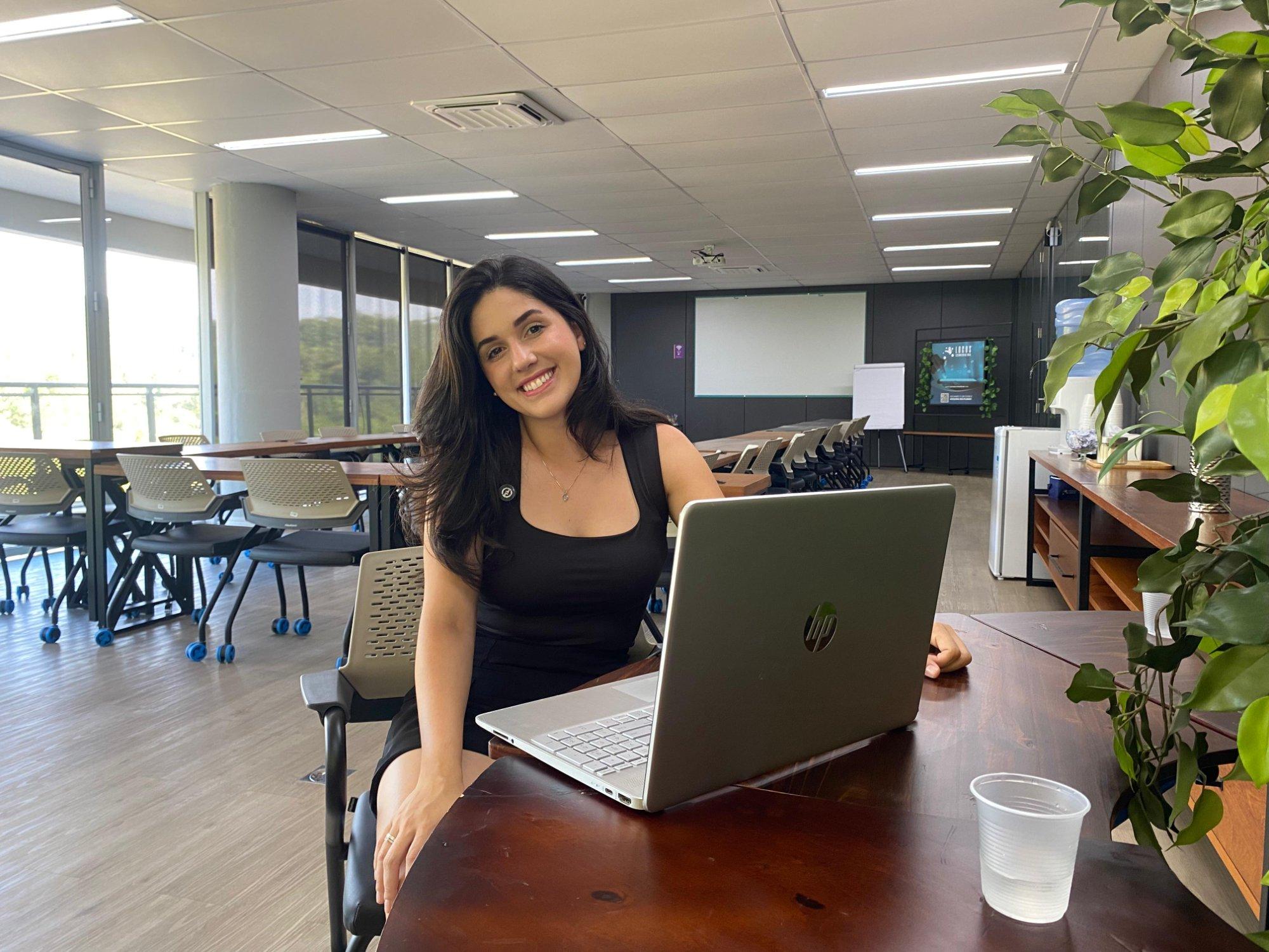 Carina working, smiling in front of her laptop